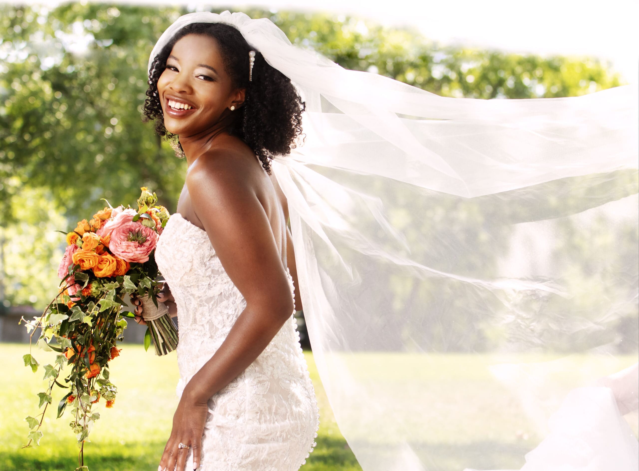 Bride in Long Veil Holding Bouquet Outdoors 