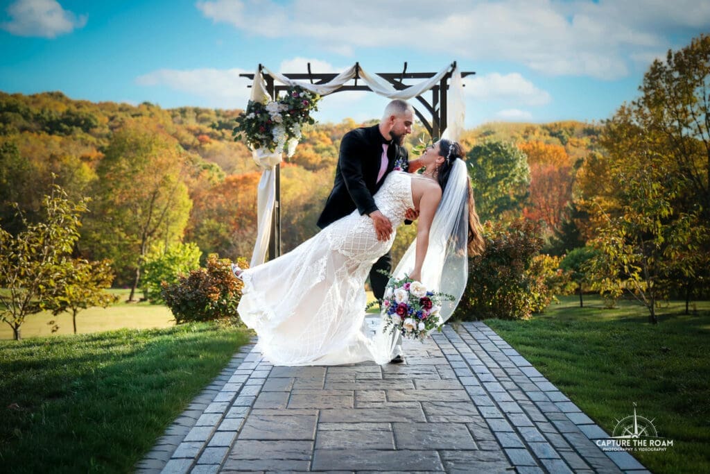 Bride and groom under floral ceremony arch at Pittsburgh wedding venue