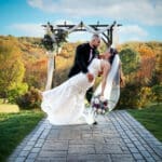 Bride and groom under floral ceremony arch at Pittsburgh wedding venue